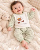 LEMCE Meadow Bear cream green textured cotton baby suit worn by smiling infant full body overhead view