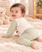 LEMCE Meadow Bear green check cotton baby suit full-body view on cream fluffy rug